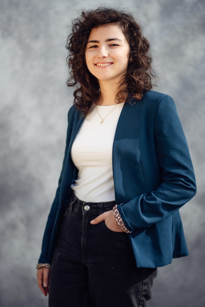 Ritratto professionale di una donna in giacca blu, su sfondo neutro. Federica Rota