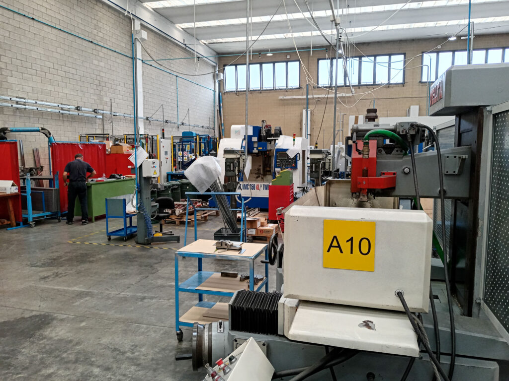 Officina meccanica con macchine utensili CNC e operatori al lavoro