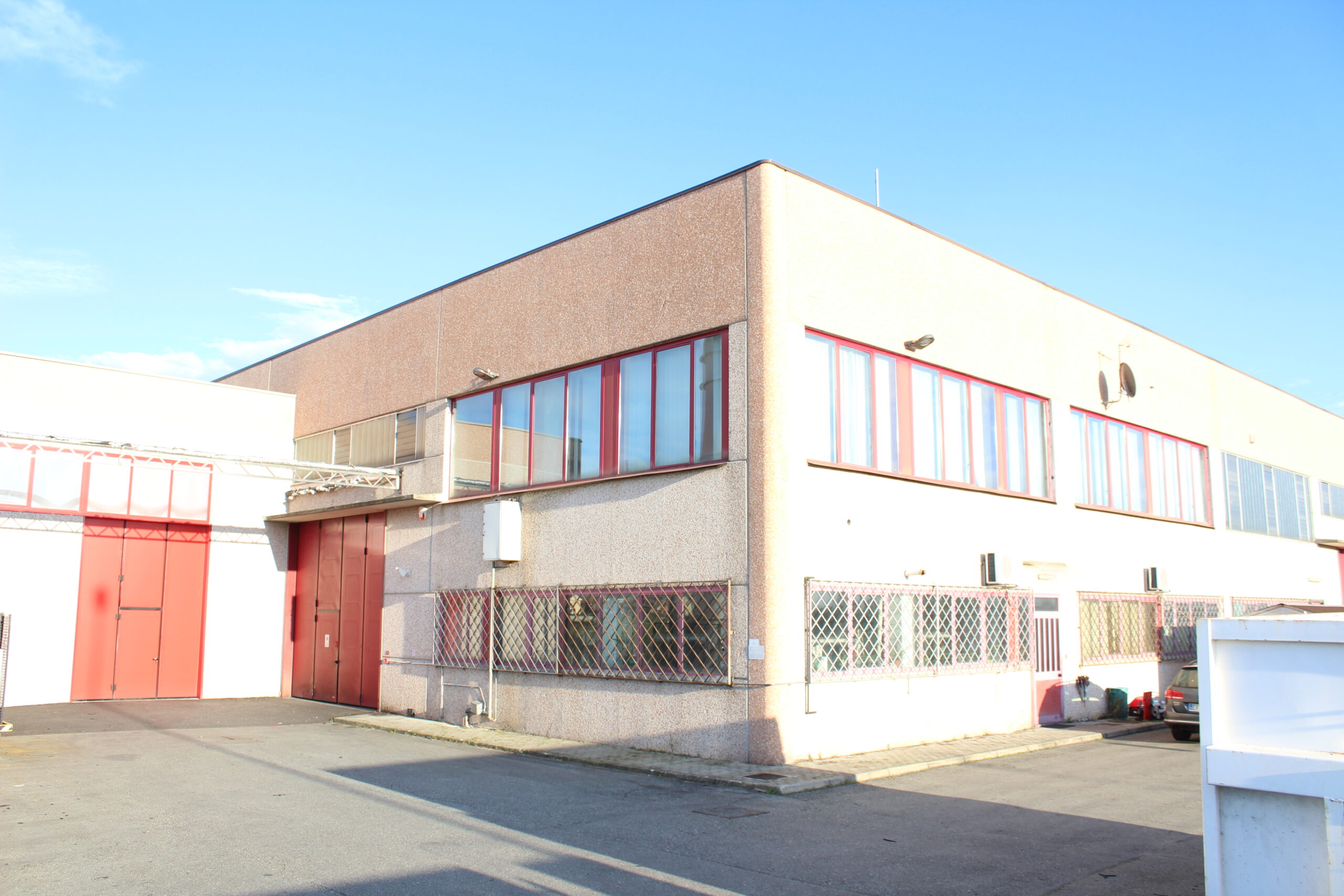 Capannone industriale moderno con ampie vetrate e accessi carrabili